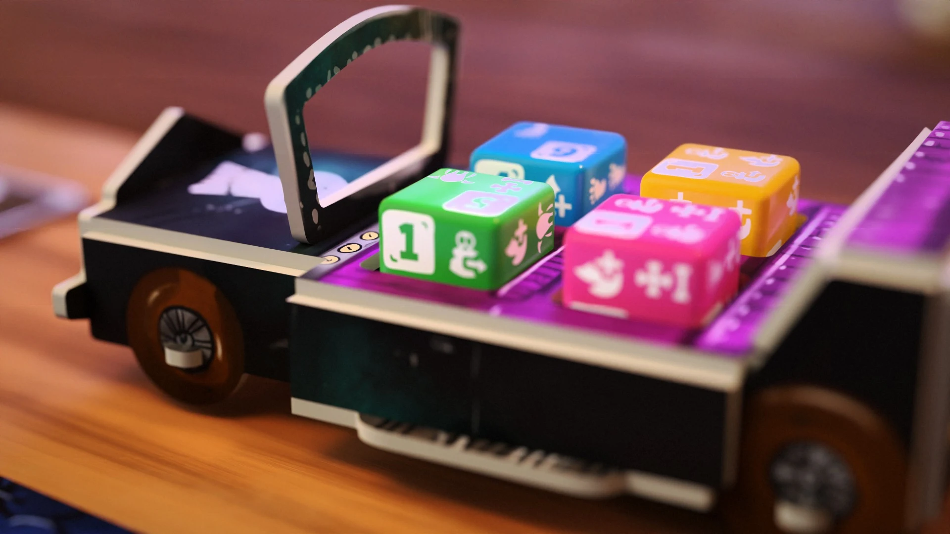 A black Fearmobile with purple seating carrying green, blue, pink, and yellow Guest Dice